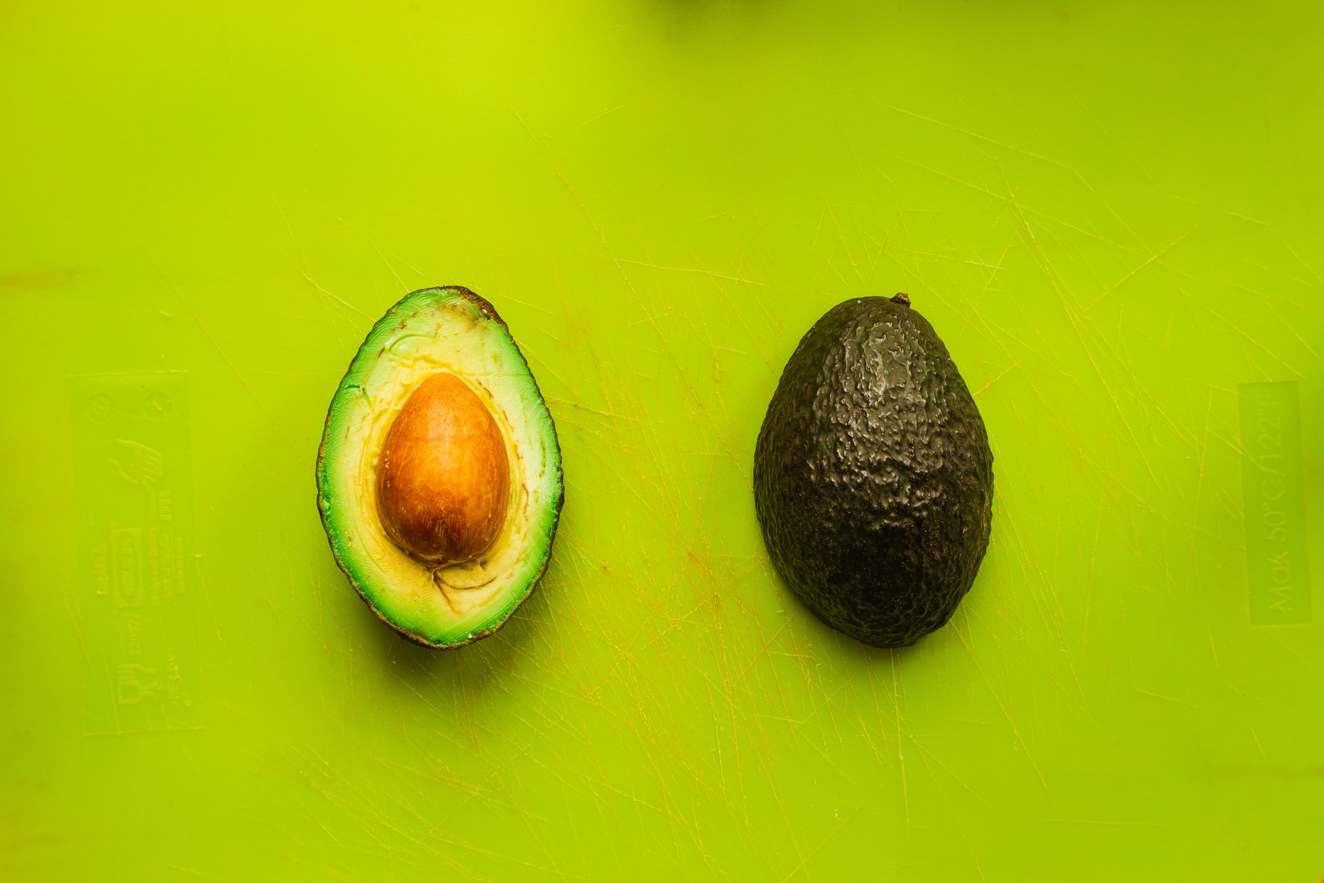 Aufgeschnittene Avocado vor grünem Hintergrund