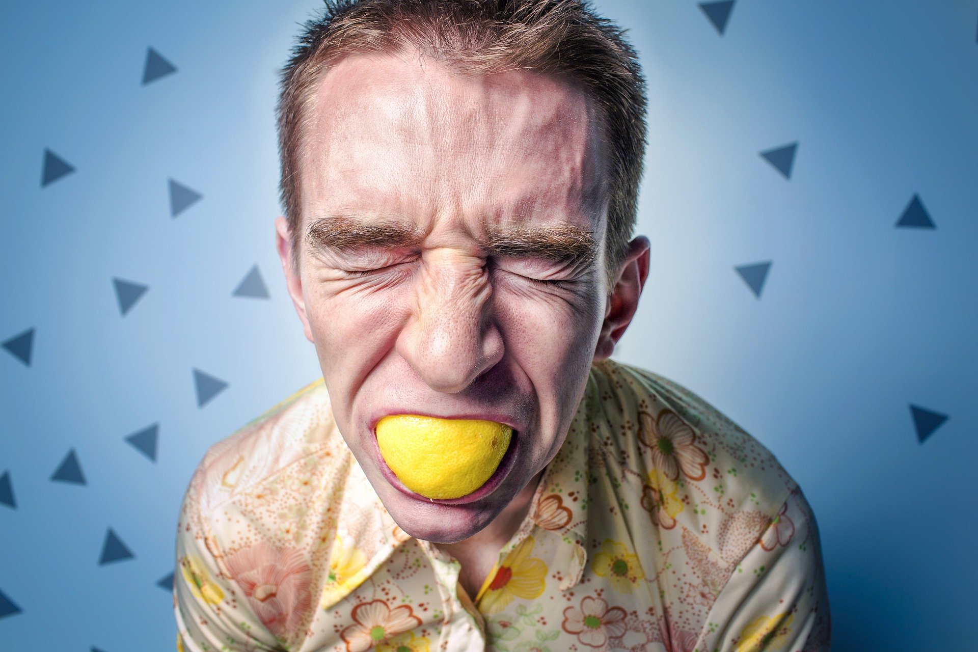 Ernährungsumstellung Mann, der auf eine Zitrone beißt